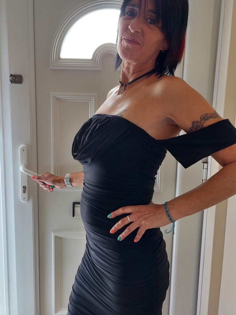 Lady wearing a block dress on her way out of the door for a night out. The sleeves are hanging down her arms