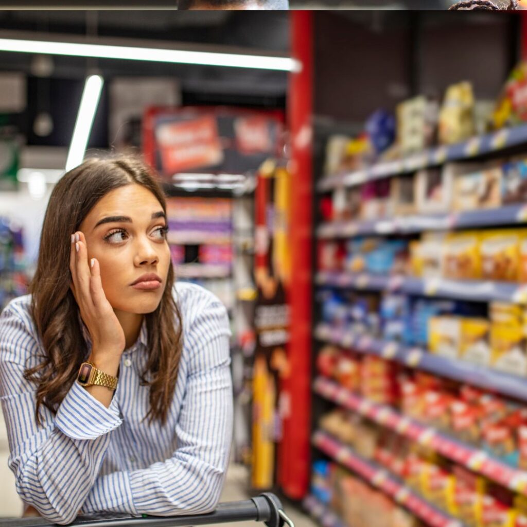 a lady saving money on the weekly shop, deciding what to buy from the shelves