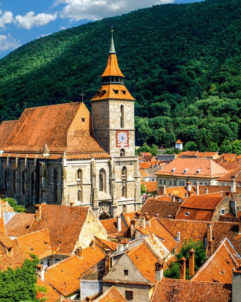 Brasov old town with orange roofed buildings and a church in the middle