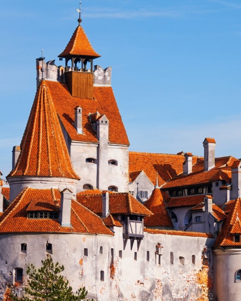 Draculas castle. It is white brick with orange coned roofs. There are small windows in the castle